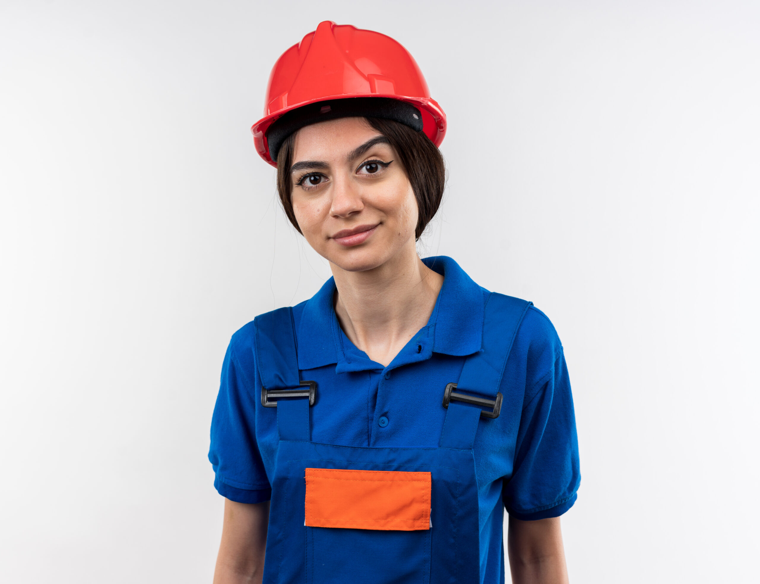 pleased looking at camera young builder woman in uniform isolated on white background
